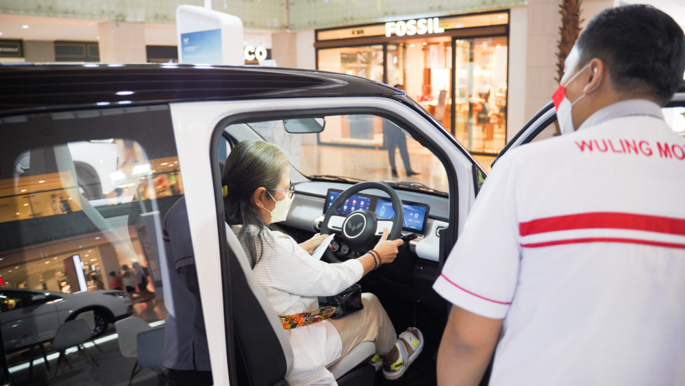 Seorang pengunjung mencoba duduk di kabin Wuling Air ev yang roomy 1000x563