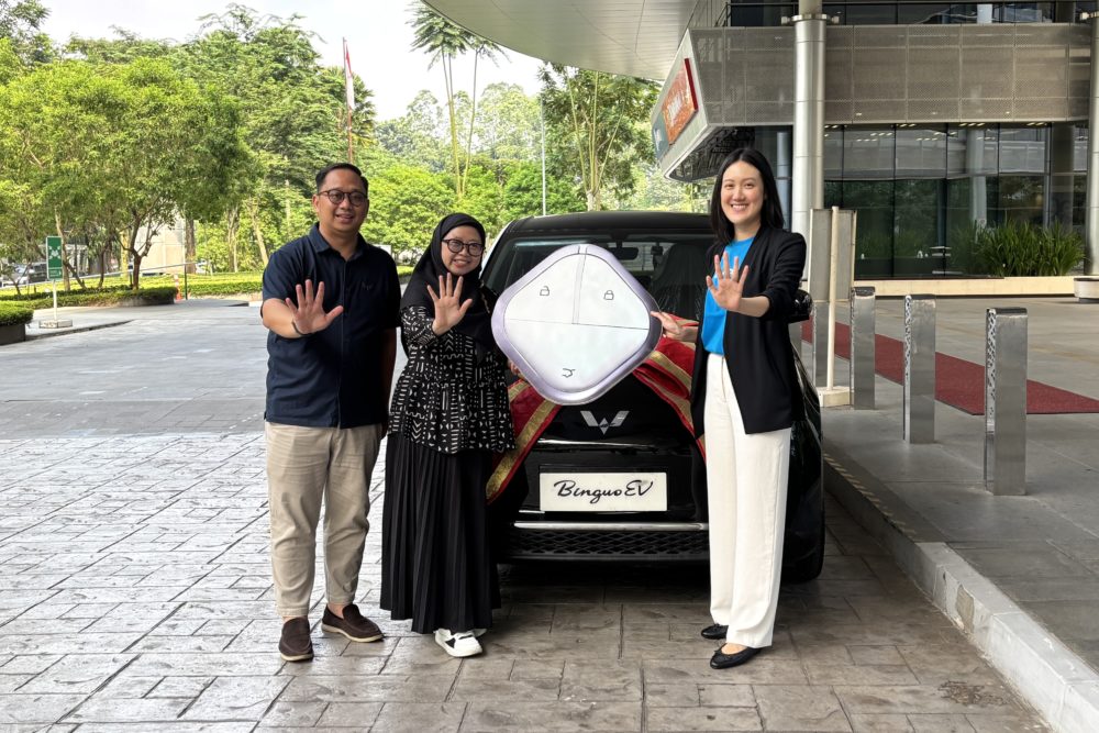 Brian Gomgom selaku Brand Communication Senior Manager Wuling Motors bersama Evelyn Limanto selaku Marketing Campaign Lead Traveloka Indonesia dengan pemenang utama Gebyar Traveloka 1000x667